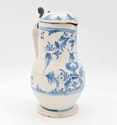 un vase bleu et blanc muni d'un couvercle, posé sur une surface blanche