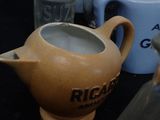 many different types of pitchers and jugs on the table