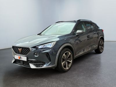 a grey car is parked in a room with a black floor