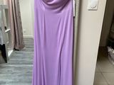 a purple dress hanging on a hanger in front of a mirror
