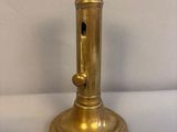 a gold colored candle holder on a white table