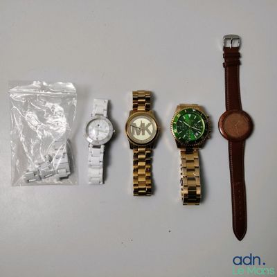 trois montres et une montre dans un sac posé sur une table