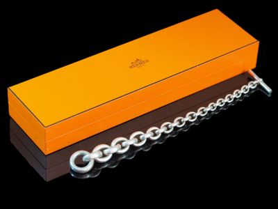 une boîte orange entourée d'une chaîne, posée sur une surface noire