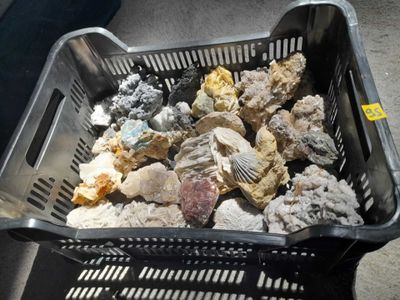 a basket full of rocks and other rocks on the ground