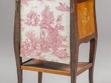an antique wooden cabinet with a pink and white toile print on it