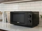 a black microwave sitting on a counter in a kitchen
