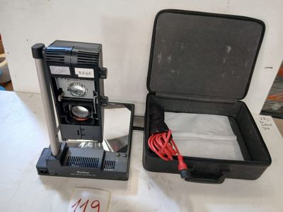 une valise noire contenant une cafetière, posée sur une table