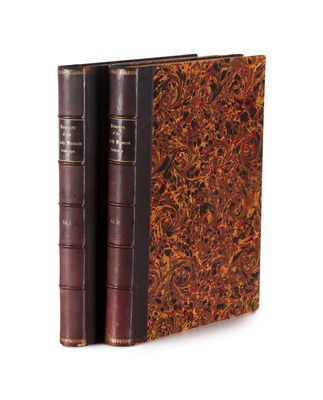 an old book with two leather bindings sitting on top of each other