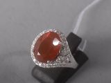 an image of a ring with a red stone surrounded by white diamonds
