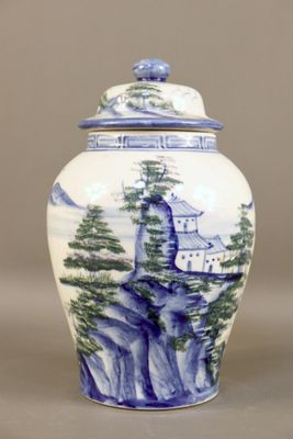 a blue and white vase with a mountain scene on it