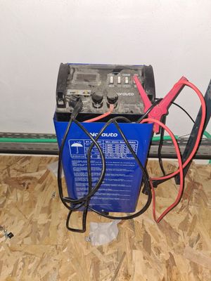 une boîte bleue sur laquelle se trouvent une batterie et un chargeur rouge et noir