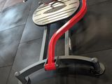 a red and black exercise bench in a gym