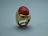 an image of a gold ring with a red stone in it