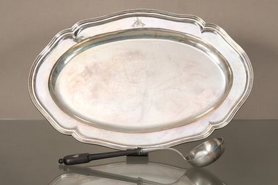 un plateau en argent avec une cuillère et un repose-cuillère posés sur une table