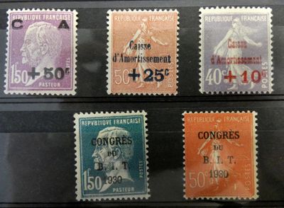 quatre timbres différents, de couleurs et de tailles variées, sur un fond noir