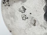 a close up of a silver plate with writing on it