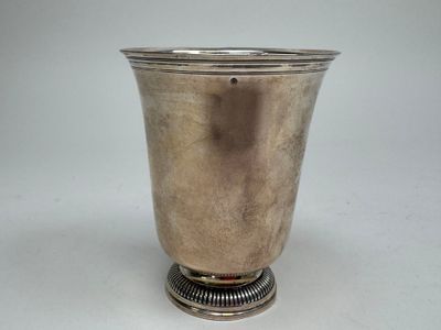 a silver vase that is sitting on a table
