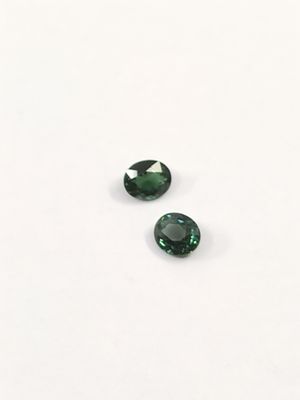 une paire de tourmalines vertes sur un fond blanc