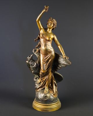 une statue antique en bronze représentant une femme accompagnée d'un chien