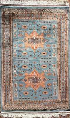 a blue rug with an orange and brown design on it