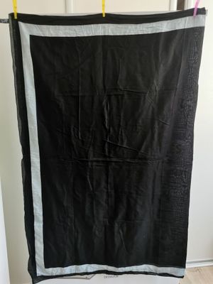 une couverture noire et blanche suspendue à un portant dans une pièce
