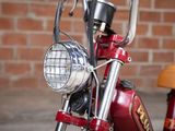 a red motorcycle parked in front of a brick wall