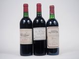 trois bouteilles de vin rouge posées l'une à côté de l'autre sur une surface blanche