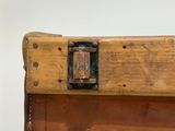 an old wooden suitcase with a metal latch on it