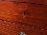 a wooden dresser with a marble top on a carpeted floor