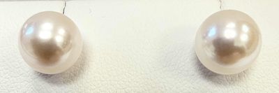 pair of pearl earrings on a white surface with a white background