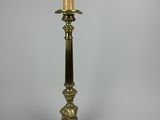 une lampe de table ancienne en laiton surmontée d'une bougie