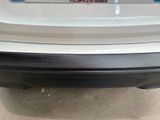 rear bumper of a white car with a sticker on it