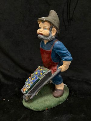 une figurine représentant un homme tenant une brouette
