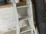 a ladder leaning against a wall next to a stack of boxes