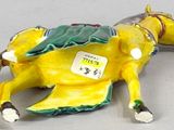 a figurine of a yellow horse with a tag on it