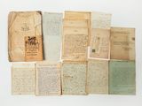 plusieurs vieux papiers sont empilés sur une surface blanche