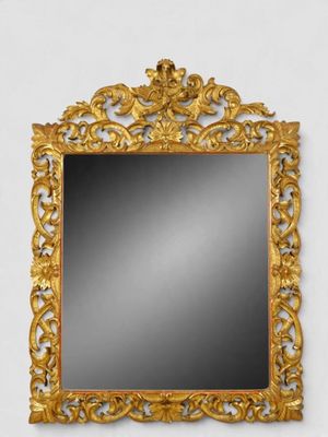 a gold framed mirror on a white wall next to a white wall