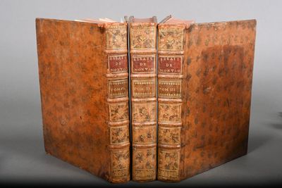 an old book is open on a table with a black background