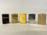 quatre briquets Zippo sont alignés sur une surface blanche
