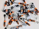 de nombreux outils à main orange et noirs posés sur une table blanche