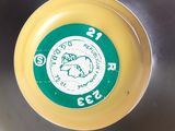 a yellow frisbee with a green and white label on it