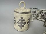 a white container with a black design on it next to other items