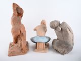 three clay sculptures of animals sitting on a white surface