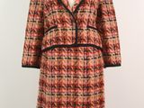 an orange and black plaid coat on a mannequin mannequin