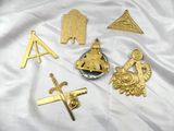 plusieurs types différents d'insignes en métal doré sur un tissu blanc