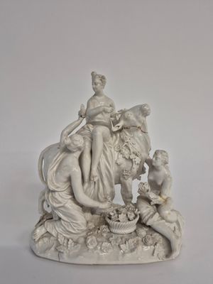 une statue représentant une femme et deux enfants assis sur un banc