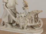 a figurine of a woman and a child on a cart