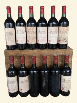 many bottles of wine sitting on a wooden shelf