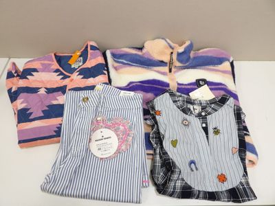 trois pyjamas et une chemise sont posés sur une table