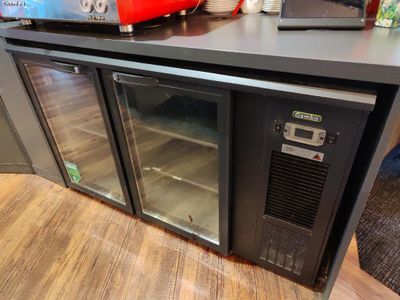une photo d'une cuisine avec un réfrigérateur et un micro-ondes